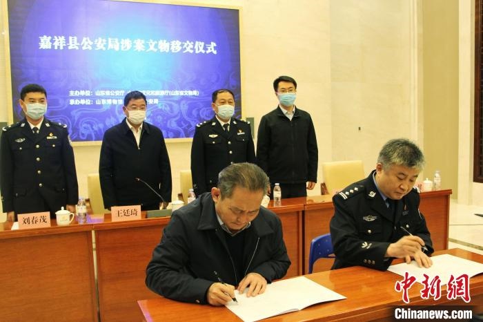 山東博物館館長(zhǎng)鄭同修和嘉祥縣人民政府副縣長(zhǎng)、公安局局長(zhǎng)趙健簽署移交協(xié)議?！≮w曉 攝