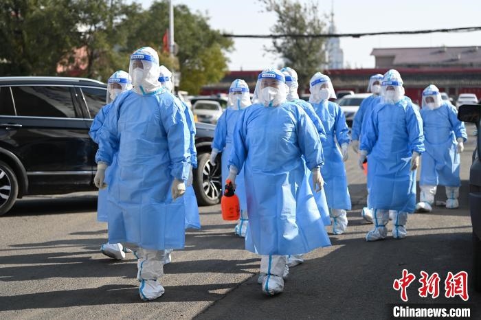 圖為醫(yī)務人員在封閉小區(qū)做防控工作?！⑽娜A 攝