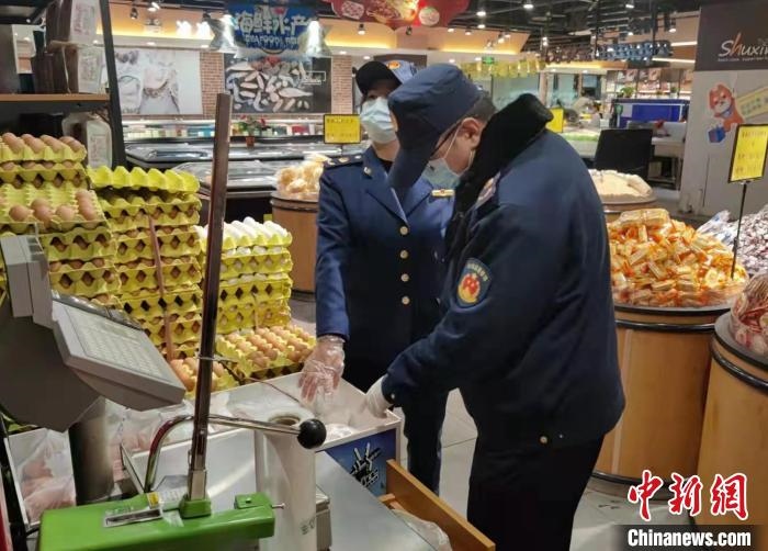 圖為疫情期間，甘肅嘉峪關市場監(jiān)管局工作人員檢查蔬菜市場?！?柴佳楠 　攝