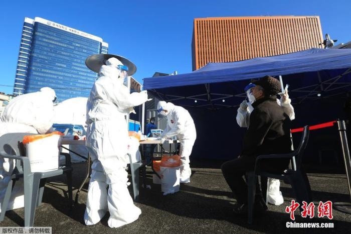 資料圖：韓國(guó)首爾，醫(yī)務(wù)人員對(duì)市民進(jìn)行新冠病毒檢測(cè)。