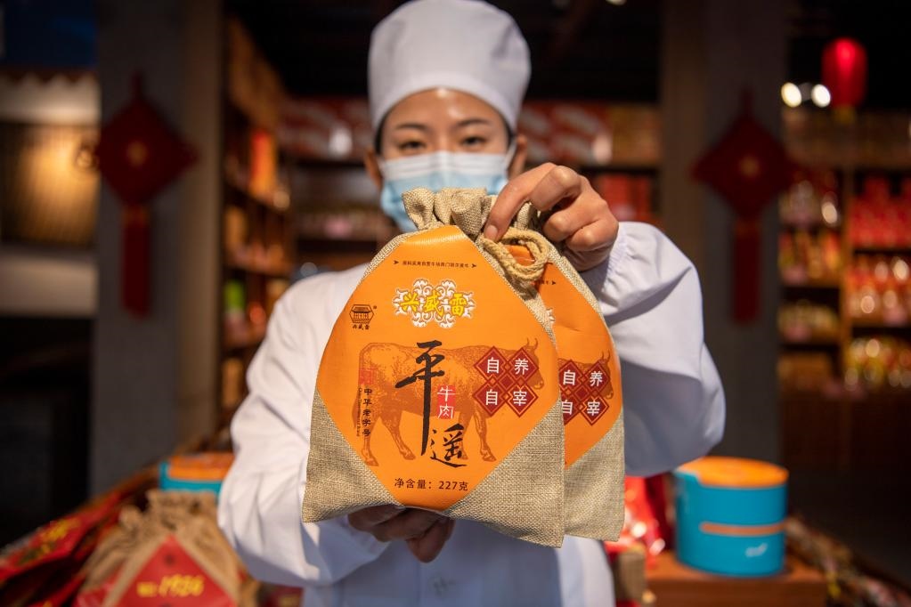 1月27日，在平遙古城南大街的一家平遙牛肉店內(nèi)，工作人員展示一款牛肉產(chǎn)品。新華社記者 楊晨光 攝