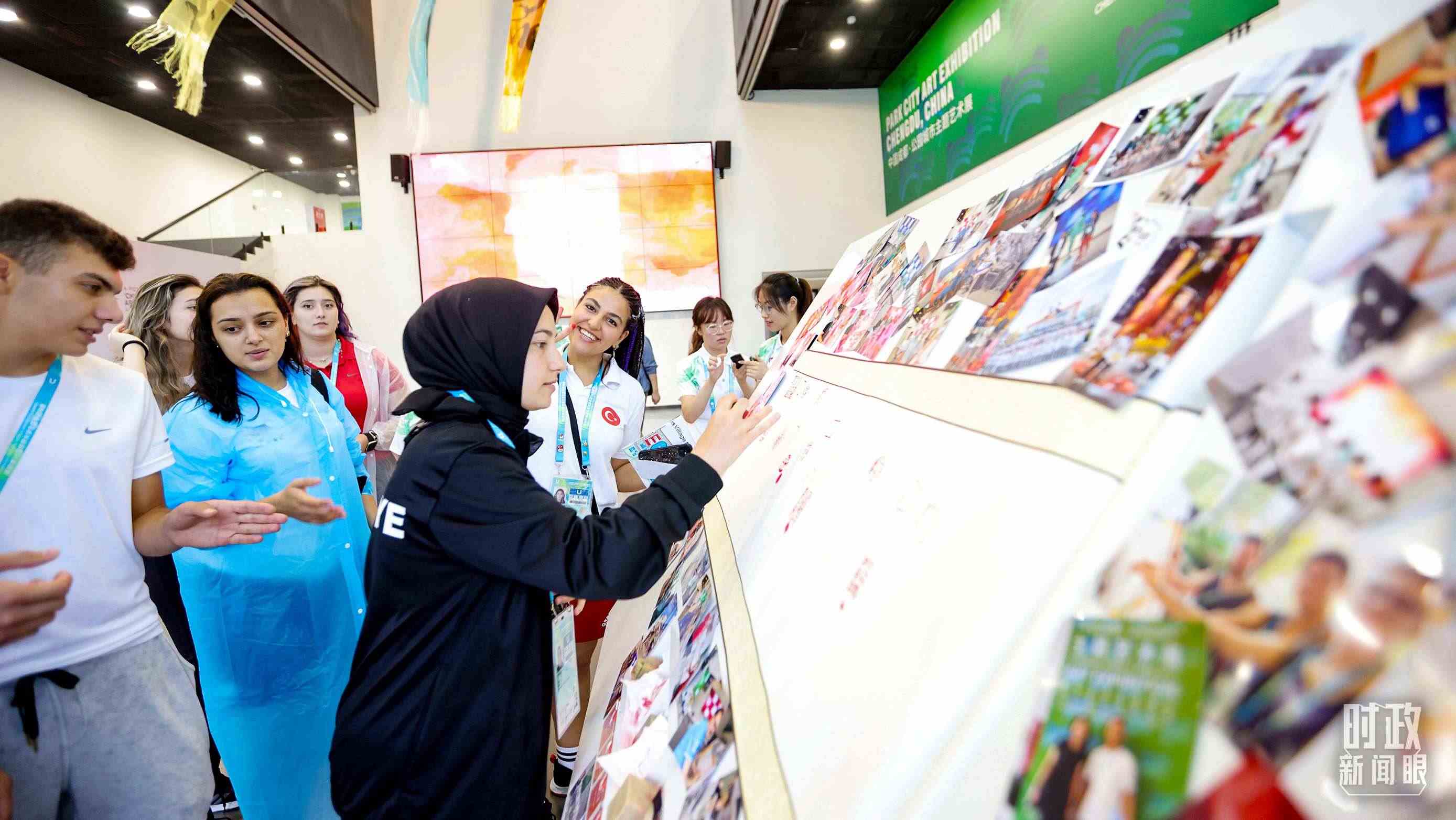 各國青年運動員正在參觀成都大運村內的“雪山下的公園城市，煙火里的幸福成都”主題藝術展。（總臺央視記者魏幫軍拍攝）
