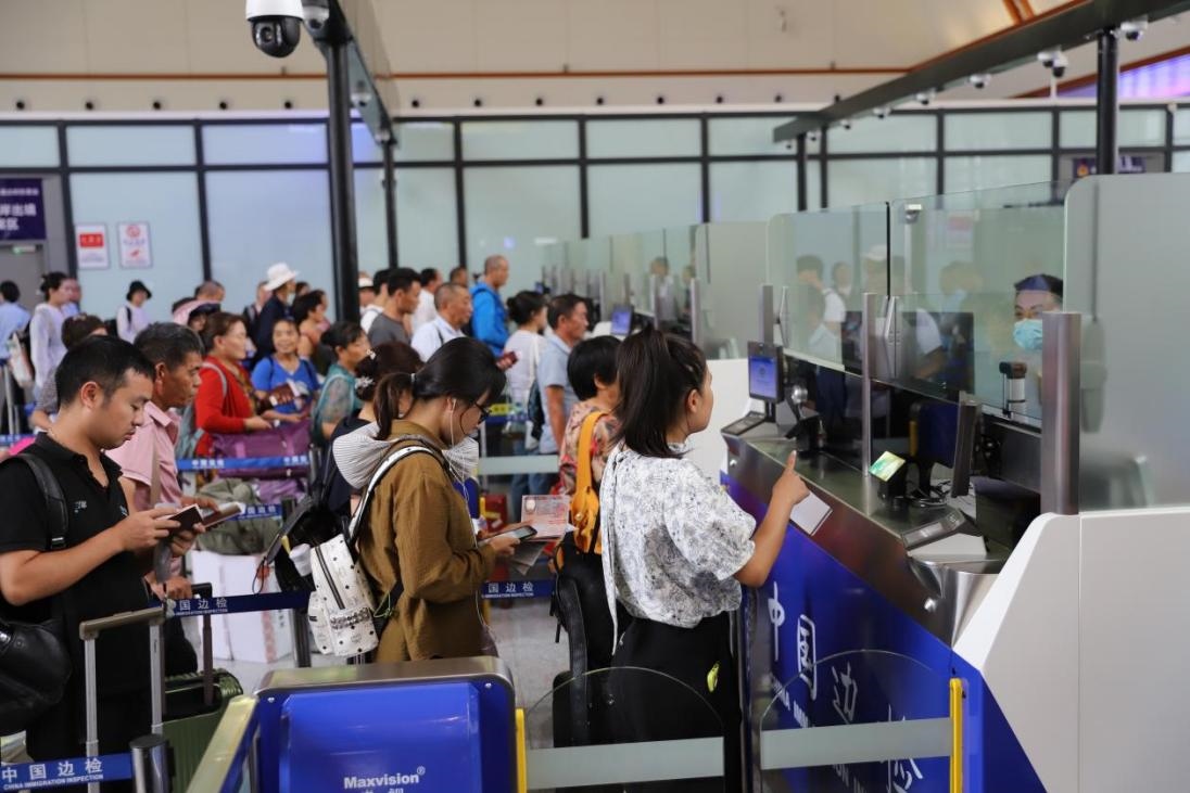出境旅客在辦理通關手續(xù)。人民網(wǎng)記者 李發(fā)興攝