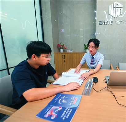 在杭州市臨安區(qū)政務(wù)服務(wù)中心的“為企服務(wù)中心”，黨員志愿者（右）解答企業(yè)主的疑問（2023年7月7日攝）。徐昱攝/本刊