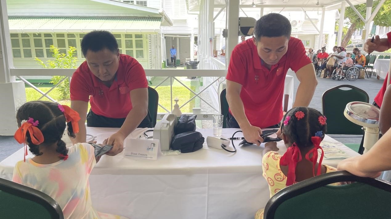 醫(yī)療隊(duì)員為福利院兒童進(jìn)行檢查。第18期援圭亞那醫(yī)療隊(duì)供圖