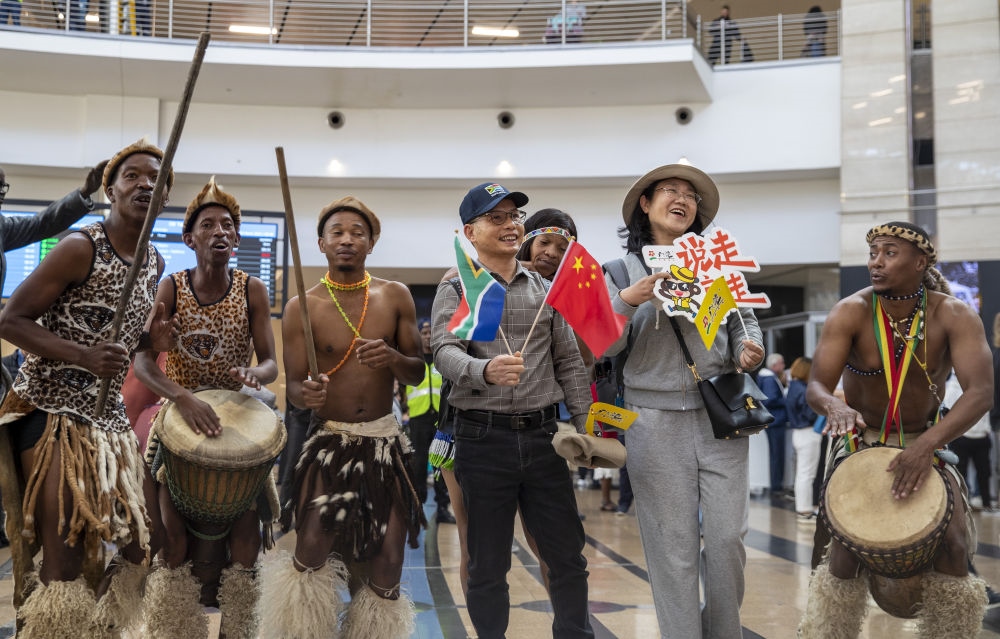 在南非約翰內(nèi)斯堡坦博國(guó)際機(jī)場(chǎng)，南非舞蹈演員歡迎中國(guó)試點(diǎn)恢復(fù)出境團(tuán)隊(duì)旅游后首批抵達(dá)南非的中國(guó)游客（2023年3月29日攝）。