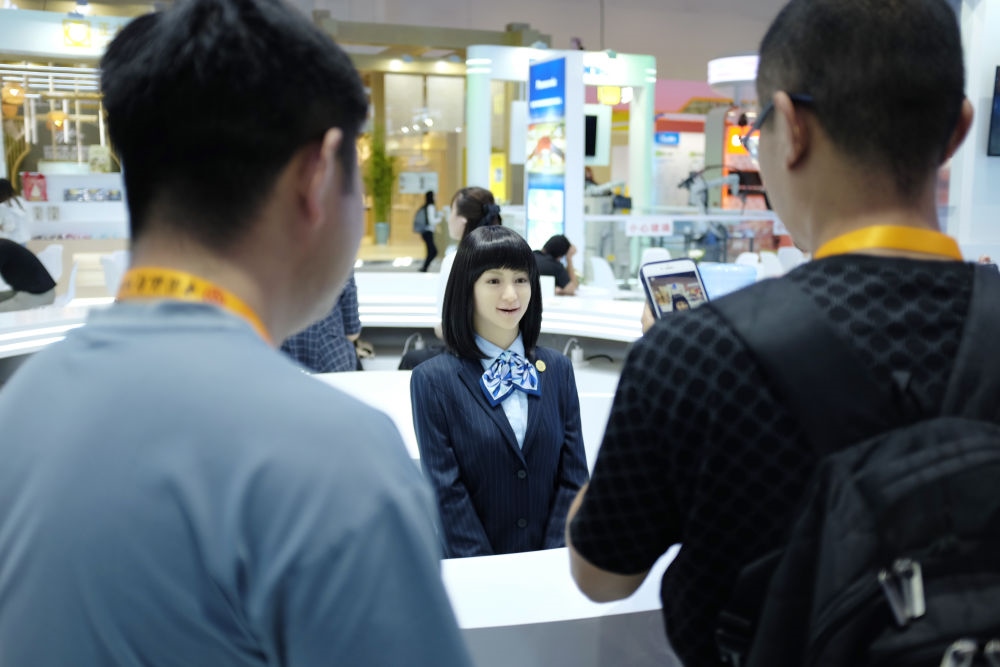 9月1日，媒體記者在國家會議中心與服務(wù)機器人互動。新華社記者 劉夢琪 攝