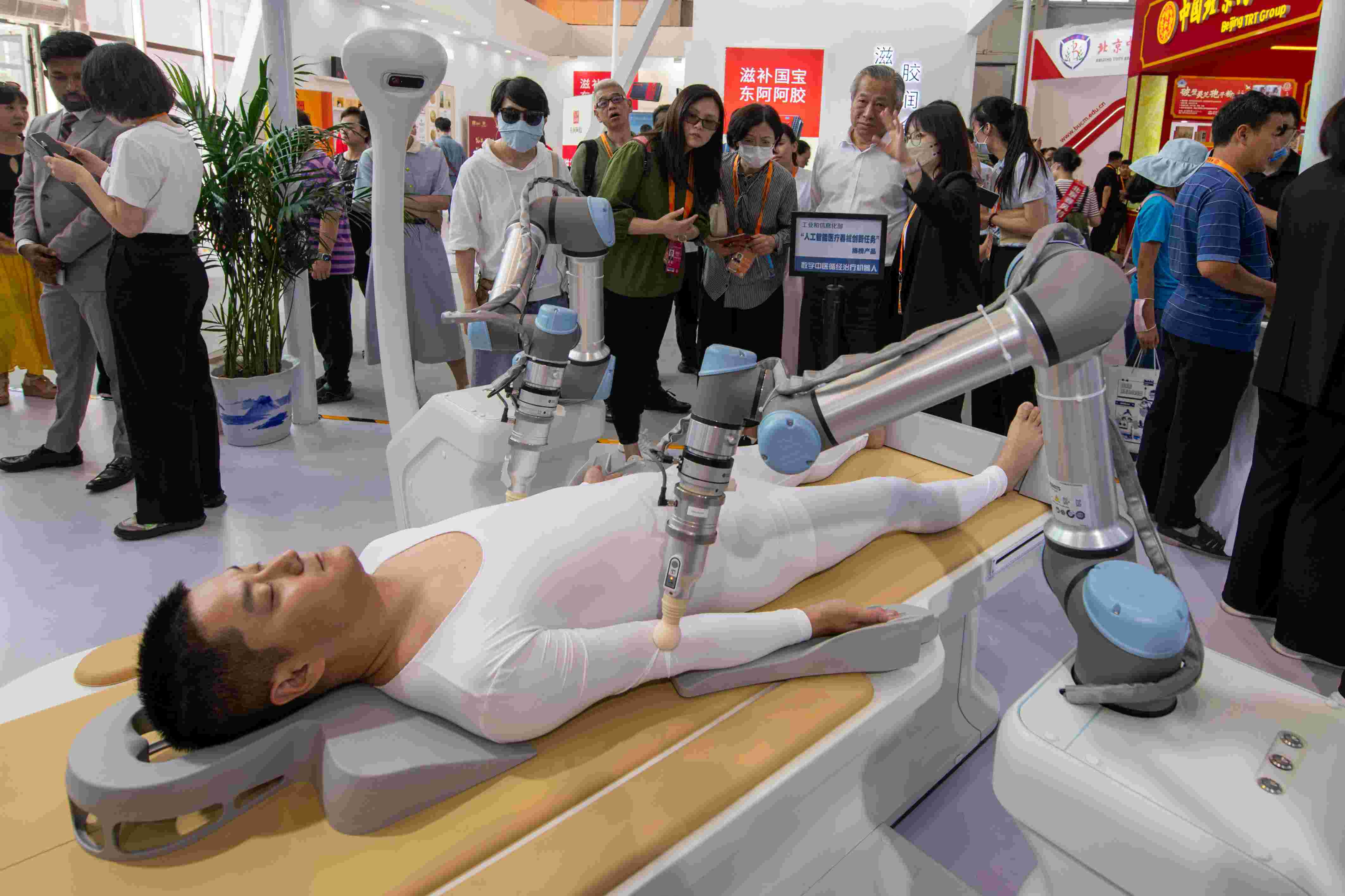 在位于首鋼園的健康衛(wèi)生服務(wù)展區(qū)，觀眾正在參觀數(shù)字中醫(yī)循經(jīng)治療機(jī)器人。人民網(wǎng)記者 翁奇羽攝