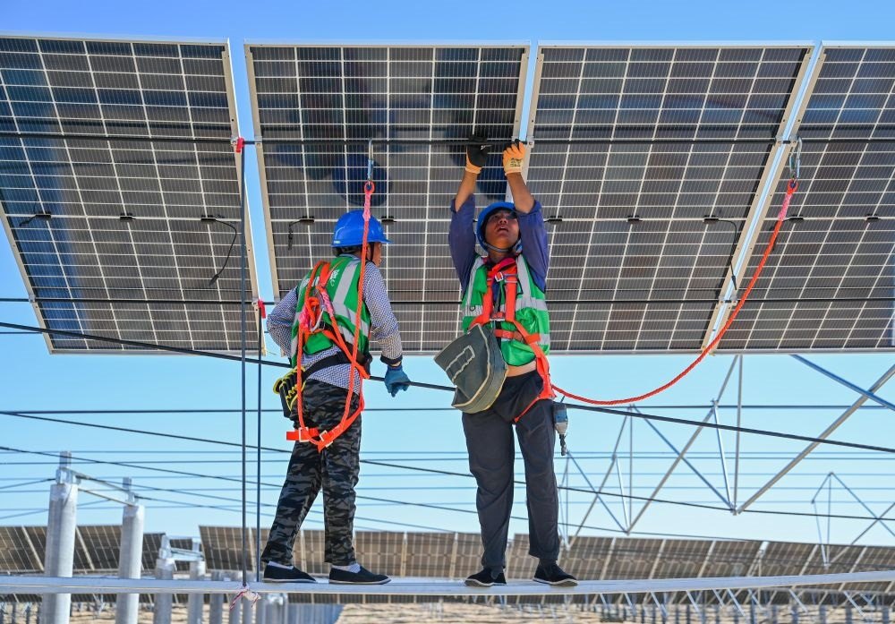2023年7月22日，工人在位于內(nèi)蒙古杭錦旗庫布其沙漠億利生態(tài)示范區(qū)的蒙西基地庫布其200萬千瓦光伏治沙項目工地安裝光伏板。新華社記者 劉磊 攝