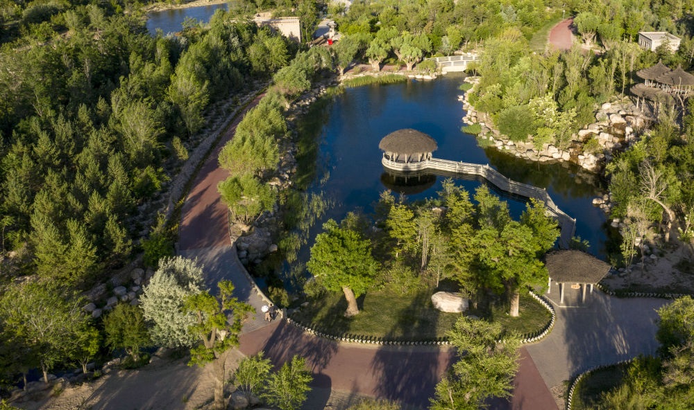 坐落在寧夏銀川市賀蘭山腳下的賀蘭山運動休閑公園（2021年5月27日攝，無人機照片）。這里曾是一片砂石采礦塌陷區(qū)，當?shù)赝ㄟ^植被景觀再造、水系建設(shè)、現(xiàn)代管網(wǎng)鋪建等手段，重新利用廢石、廢坑及各類廢棄建筑材料，把這里變成一座免費開放的主題公園。新華社記者 馮開華 攝