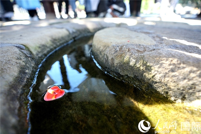 圖為水渠里流過的“桃心”蠟燭。人民網 盧鵬宇攝