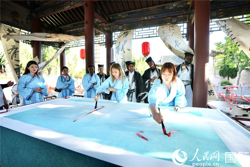 選手們提筆書寫“家園”二字。人民網 盧鵬宇攝