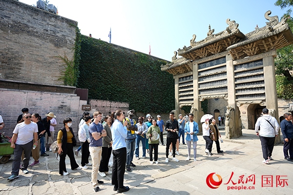 選手們認真聆聽導游講解。人民網(wǎng) 盧鵬宇攝