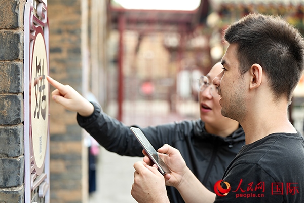 選手安德烈（俄羅斯）在老師指導下學習墻壁上張貼的生僻字。人民網(wǎng) 盧鵬宇攝