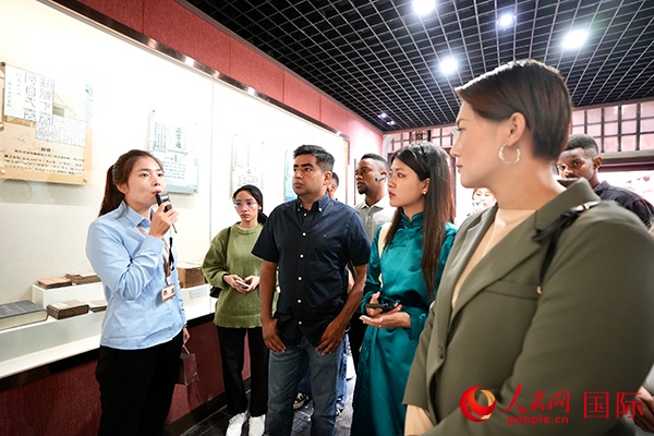 選手們認真聆聽導游講解。人民網(wǎng) 盧鵬宇攝