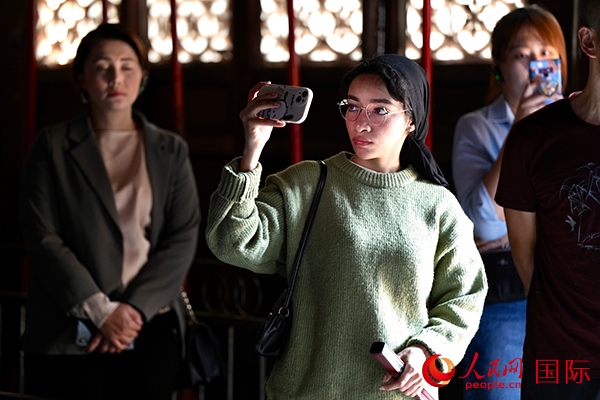 選手顏青（蘇丹）用手機記錄所見所感。人民網(wǎng) 盧鵬宇攝