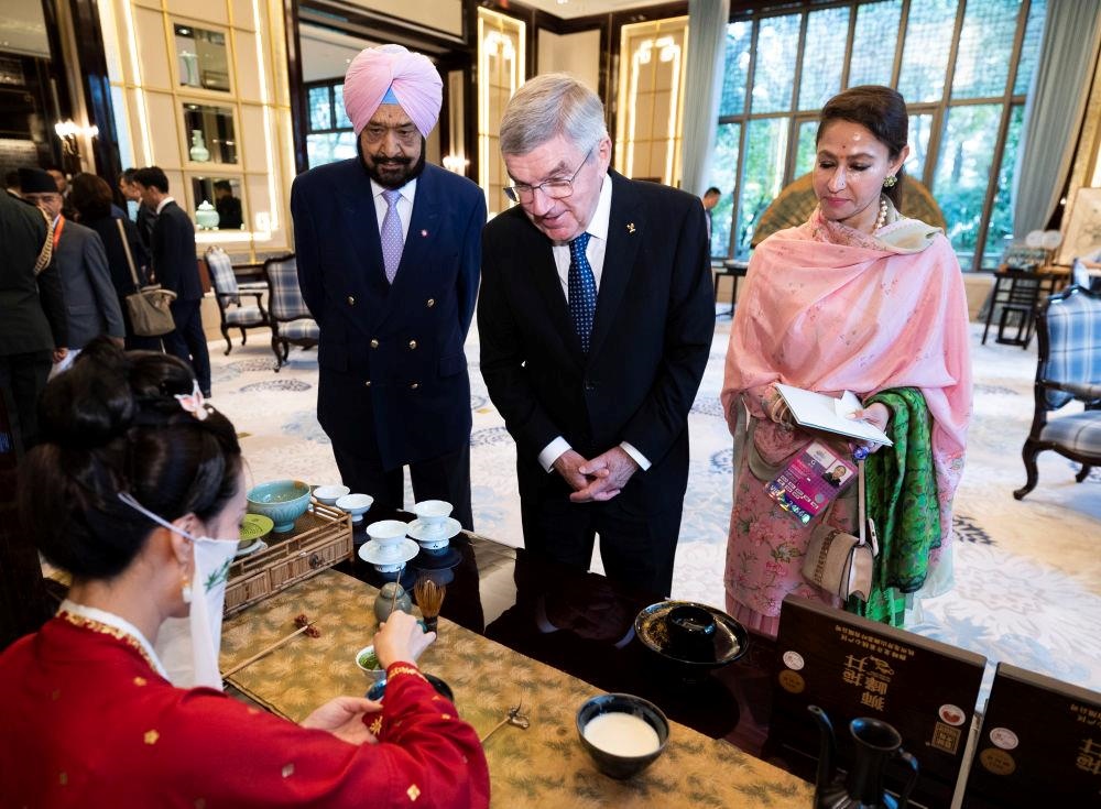 △歡迎宴會前，亞奧理事會代理主席辛格和夫人維尼塔、國際奧委會主席巴赫欣賞非遺展示。