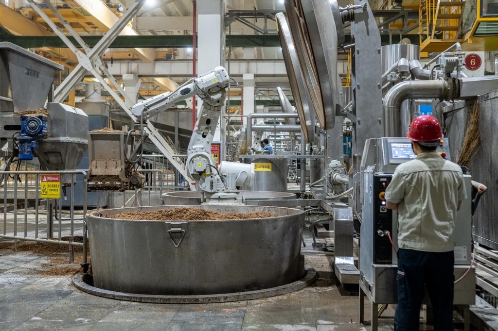 907車間里，機(jī)械臂正在撒料裝甑。嚴(yán)磊攝