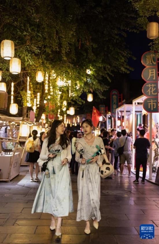 在成都寬窄巷子，兩位來(lái)自安徽的游客在新“十二月市”街區(qū)游覽（9月29日攝）。