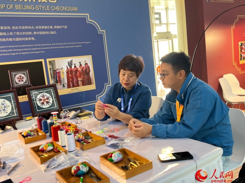 記者在新聞中心非遺傳承人展區(qū)進(jìn)行體驗(yàn)。人民網(wǎng)記者 杜燕飛攝