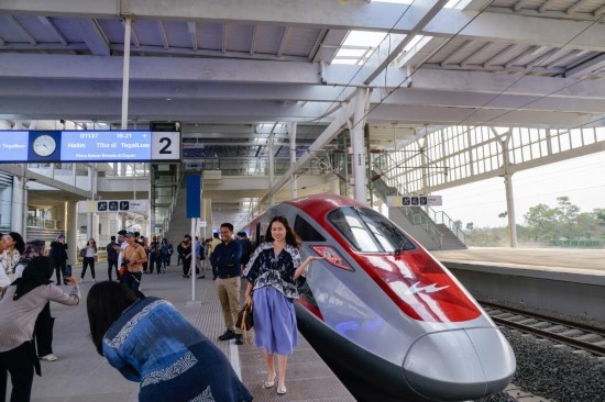  10月17日，在印度尼西亞萬(wàn)隆德卡魯爾站，乘客在站臺(tái)上和雅萬(wàn)高鐵高速動(dòng)車組列車合影。新華社記者 徐欽 攝