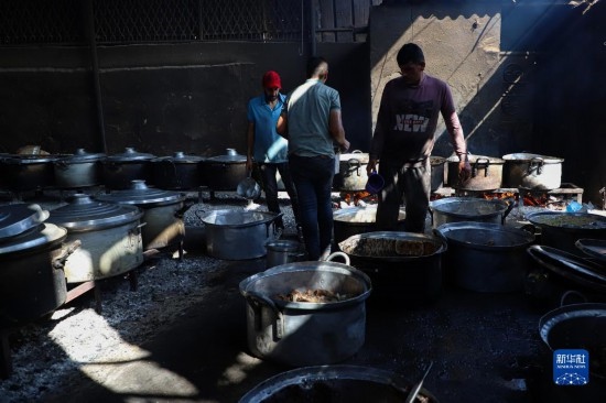 11月3日，在加沙地帶南部城市拉法，人們?cè)诿簹庵袛嗪笥貌窕鹱鲲?。新華社發(fā)（里澤克·阿卜杜勒賈瓦德攝）