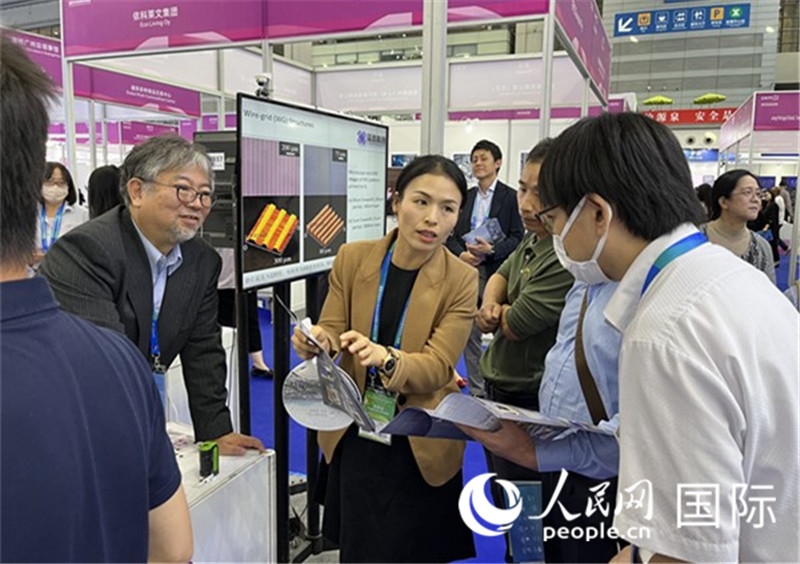 工作人員向參觀者介紹超級(jí)噴墨技術(shù)。（人民網(wǎng)記者 陳思攝）