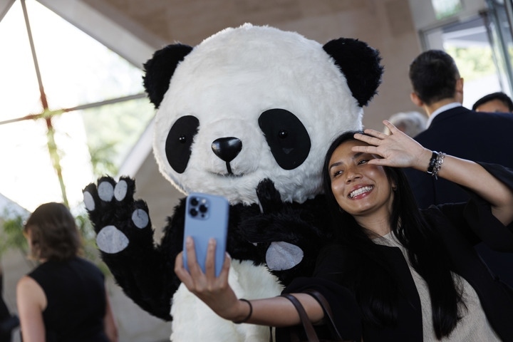 2022年8月24日，在美國華盛頓中國駐美國大使館，來賓與大熊貓玩偶合影。