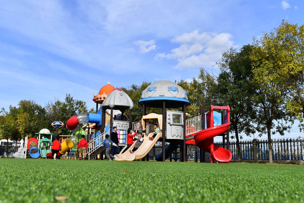 在山東省東營市墾利區(qū)楊廟社區(qū)幼兒園，孩子們在老師的帶領下進行戶外活動（2021年10月19日攝）。新華社記者 郭緒雷 攝