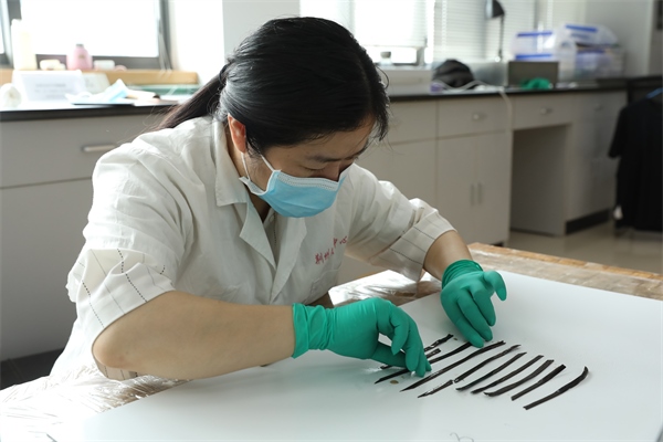 考古工作者正給竹簡(jiǎn)排序。國(guó)家文物局供圖