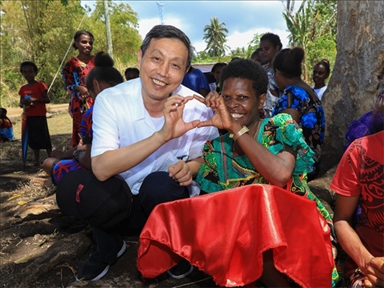 2023年12月18日，中國(guó)駐瓦努阿圖大使李名剛和前來(lái)觀看瓦努阿圖公路項(xiàng)目二期馬勒庫(kù)拉段移交儀式的當(dāng)?shù)鼐用窈嫌?。人民網(wǎng) 賀吉攝