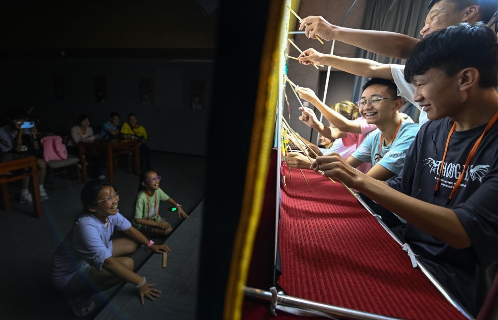 2023年8月8日，進行暑期研學(xué)的學(xué)生在位于陜西省西安市的中國秦腔藝術(shù)博物館體驗皮影戲演出。新華社記者 鄒競一 攝