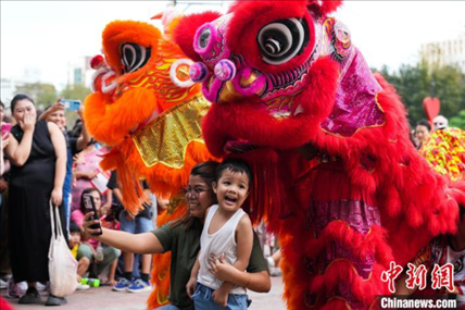 圖為舞獅表演吸引民眾合影。張興龍攝