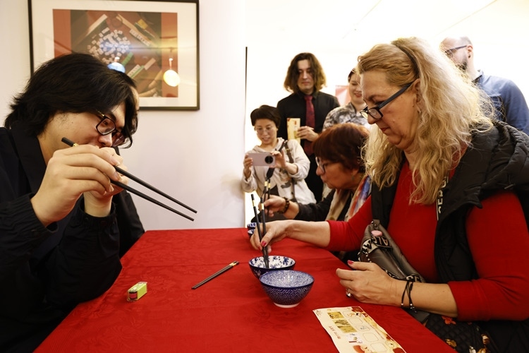 羅馬尼亞觀眾體驗用筷子夾花生。中國文化中心供圖