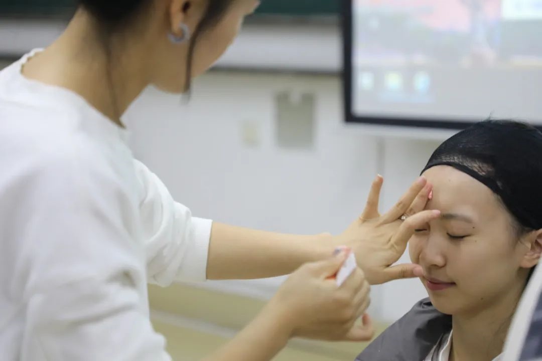 課堂上，一名學(xué)生在體驗(yàn)上戲妝。學(xué)校供圖