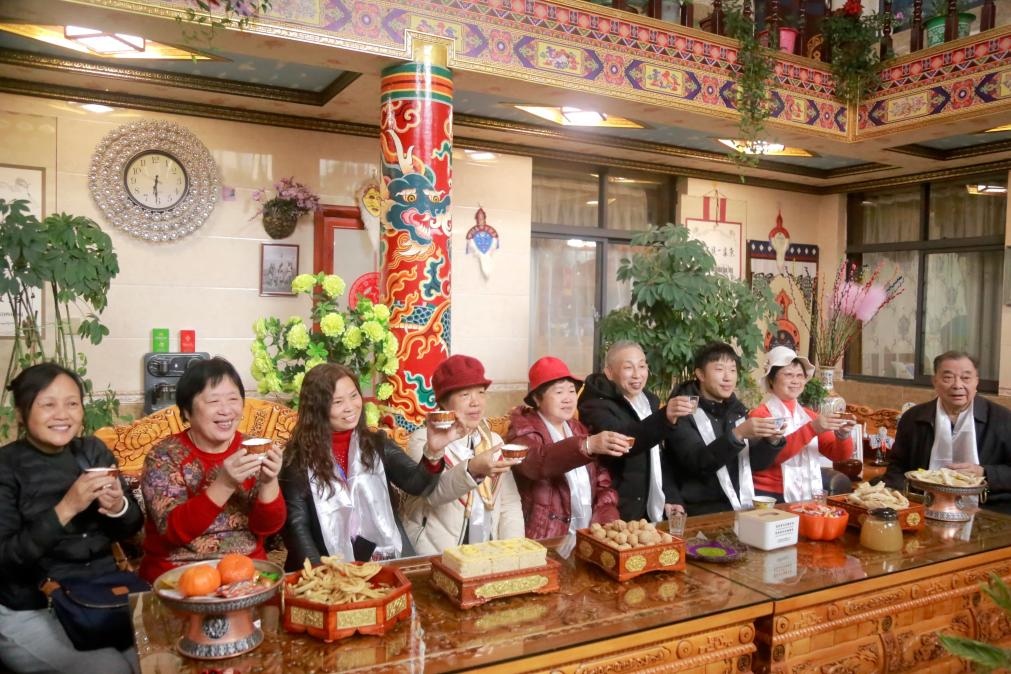 游客們?nèi)胱∶袼藓?，舉杯共飲酥油茶。新華社記者 邱星翔 攝
