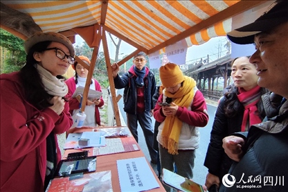 1月6日，“2024成都蒲江柑甜采摘節(jié)”上，記者見到了小萌（左一）和許多年輕人忙著做訪客接待、現(xiàn)場布置、票務(wù)核對、采摘服務(wù)等工作。人民網(wǎng)記者朱虹攝