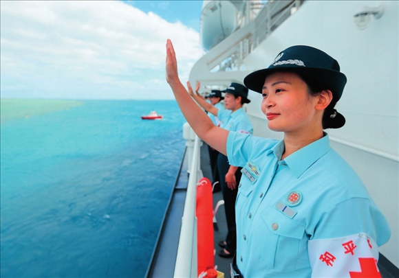 中國(guó)海軍“和平方舟”號(hào)醫(yī)院船結(jié)束訪問(wèn)湯加時(shí)，任務(wù)官兵中的文職人員向歡送人群揮手告別（2023年8月4日攝）。徐巍攝/本刊