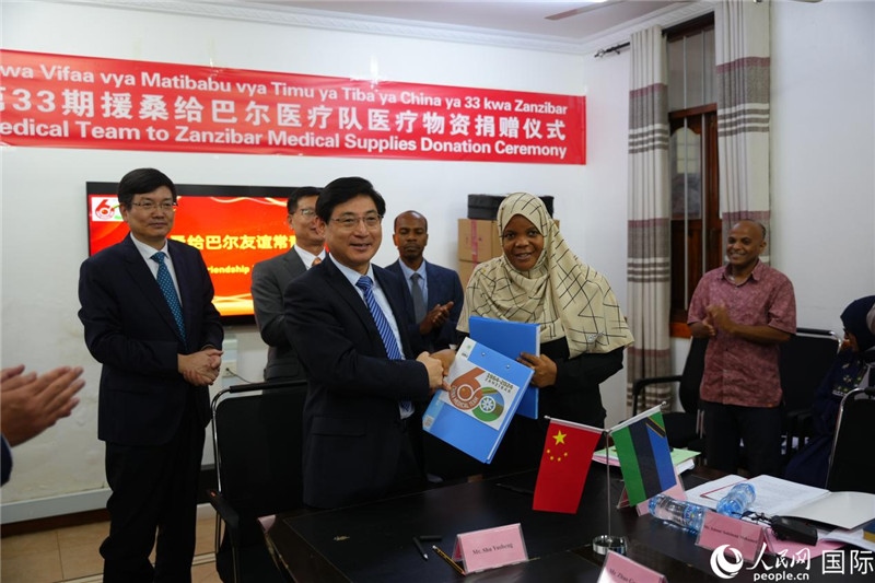 江蘇省蘇北人民醫(yī)院黨委書記束余聲與桑衛(wèi)生部首席秘書哈比巴交換捐贈書。中國援桑醫(yī)療隊供圖