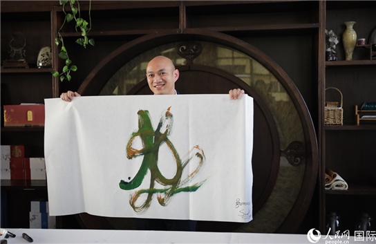 老撾駐華大使館三秘明君參加《五百筆·瀾湄合作》集體藝術(shù)創(chuàng)作。人民網(wǎng)王婧攝。