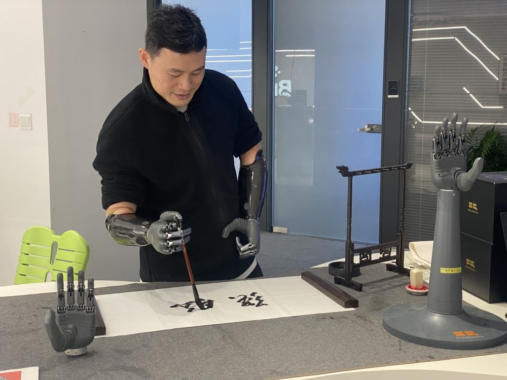 2024年3月29日，在浙江強(qiáng)腦科技有限公司展廳內(nèi)，失去雙手的產(chǎn)品體驗(yàn)官倪敏成依靠智能仿生手寫毛筆字。新華社記者 魏一駿 攝