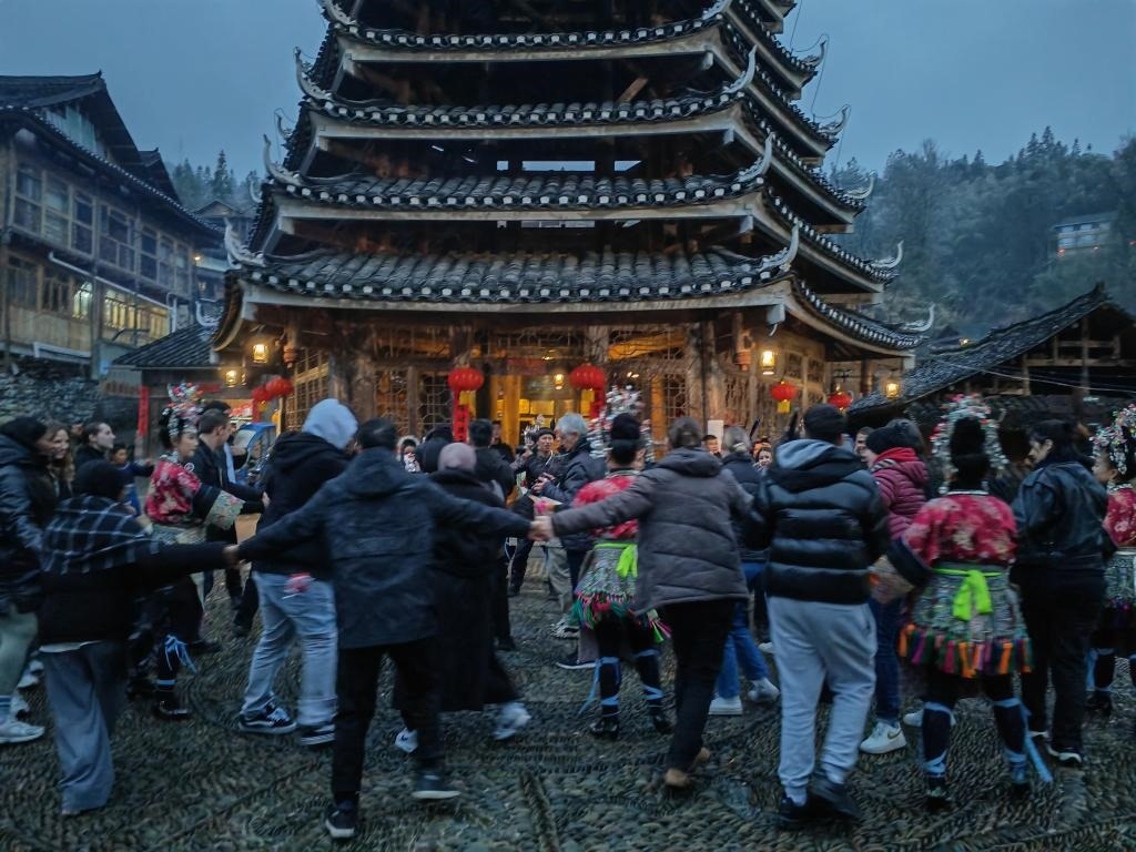 法國青年與當?shù)卮迕駹渴痔?。新華社記者 羅羽 攝