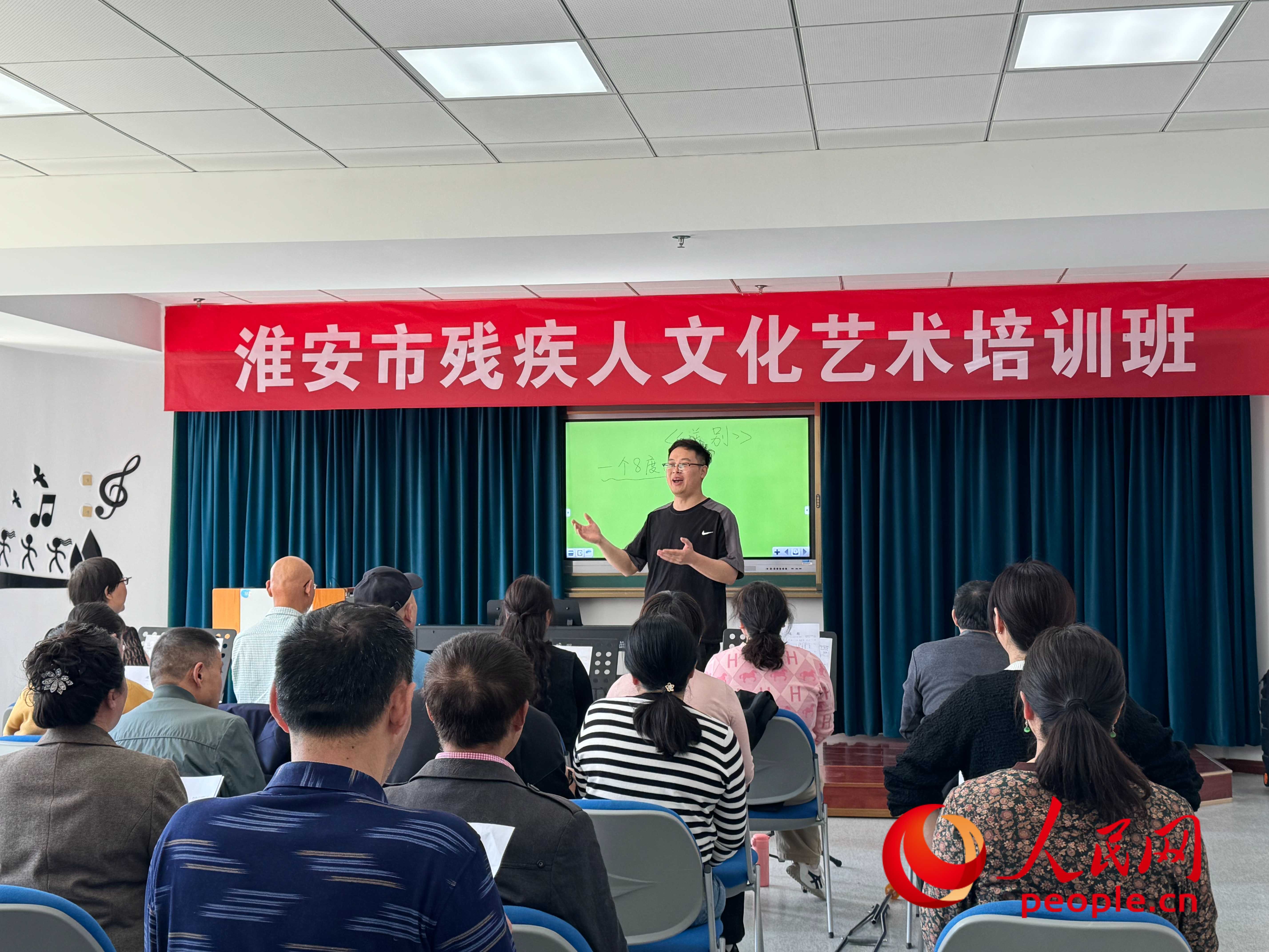 在淮安市殘疾人文化藝術(shù)培訓班上，聲樂老師在教殘疾人唱《送別》這首歌曲。人民網(wǎng) 周靜圓攝