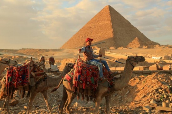 1月24日，商販騎駱駝離開埃及吉薩金字塔景區(qū)。新華社記者 隋先凱 攝