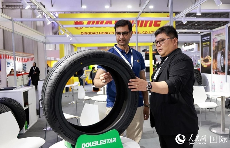 工作人員向客戶展示雙星電動(dòng)汽車輪胎。和傳統(tǒng)汽車輪胎相比，電動(dòng)汽車輪胎具有更高承載能力、更加靜音舒適、更好極速抓地、更低滾動(dòng)阻力等特點(diǎn)。人民網(wǎng)記者 管克江攝