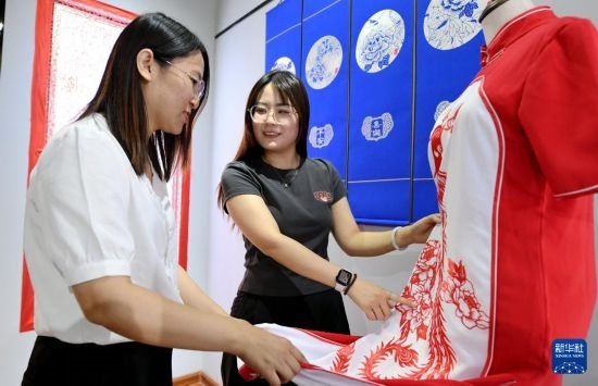 5月31日，在衡水市阜城縣一家剪紙工作室，游客在觀賞帶有剪紙元素的旗袍。