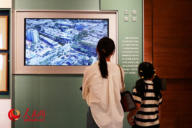 家長正在帶孩子參觀“輝煌中軸”專題展。人民網(wǎng)記者 韋衍行攝