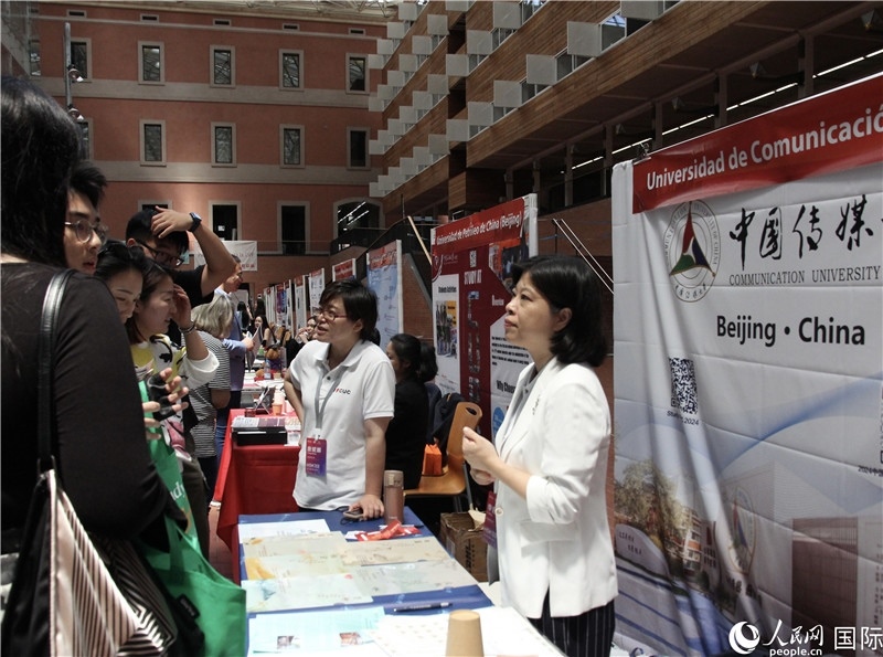 旅西華人華僑在展臺前咨詢。人民網(wǎng)記者 許海林?jǐn)z