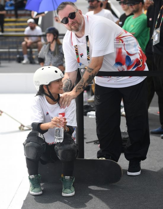 6月20日，鄭好好（左）在比賽間隙與教練互動(dòng)，她在預(yù)賽中最佳成績(jī)?yōu)?2.60分。當(dāng)日，巴黎奧運(yùn)會(huì)資格系列賽布達(dá)佩斯站滑板女子碗池預(yù)賽在布達(dá)佩斯舉行。新華社記者 賀燦鈴 攝