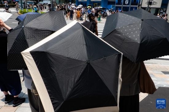 7月4日，人們?cè)谌毡緰|京原宿的街道上等待紅綠燈。新華社記者 張笑宇 攝